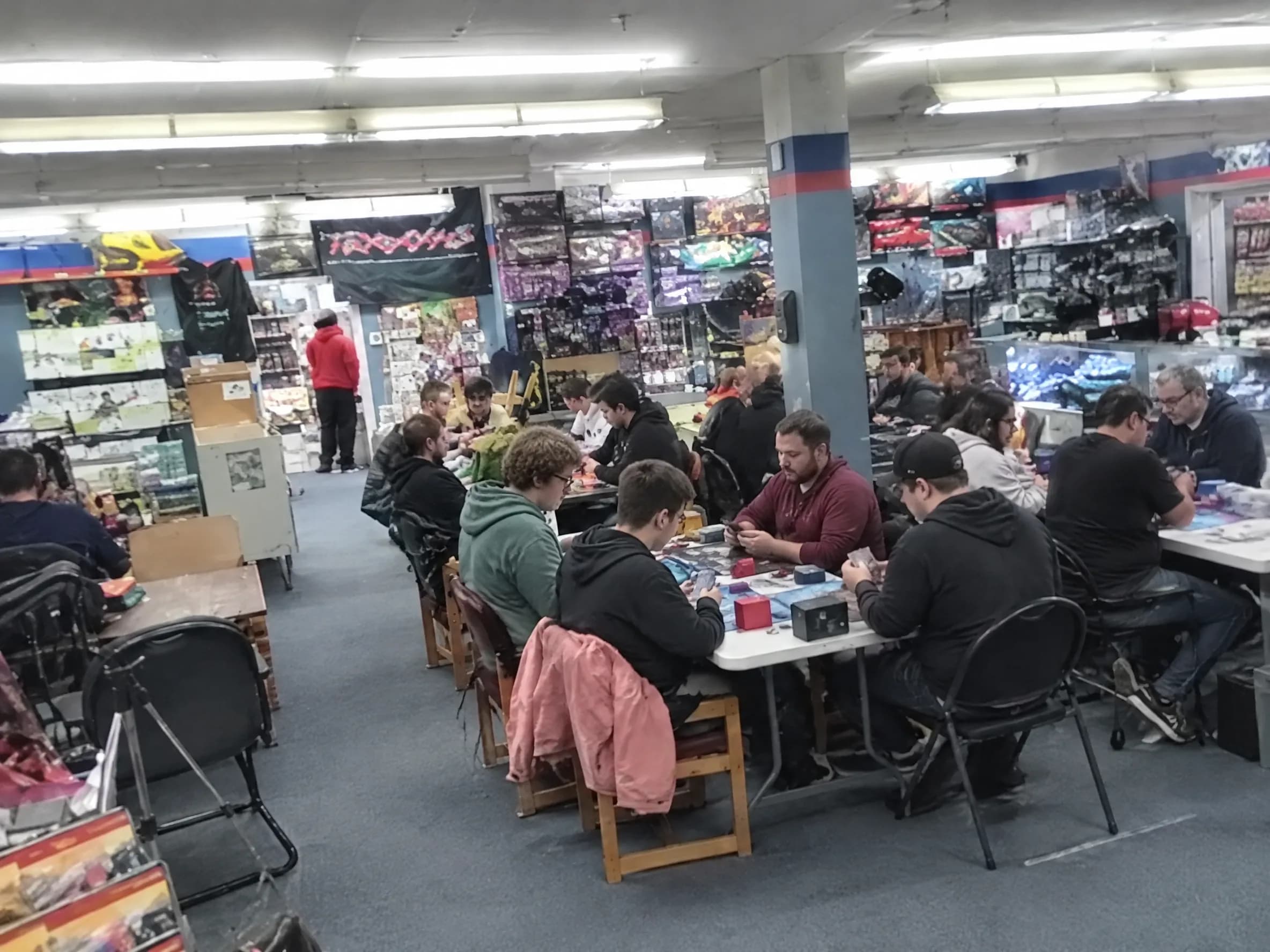 Four focused players at a competitive Commander table.